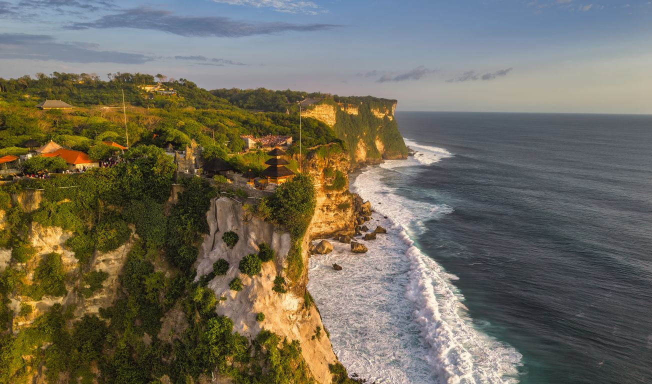The Uluwatu cliffline at golden hour, seen from the air
