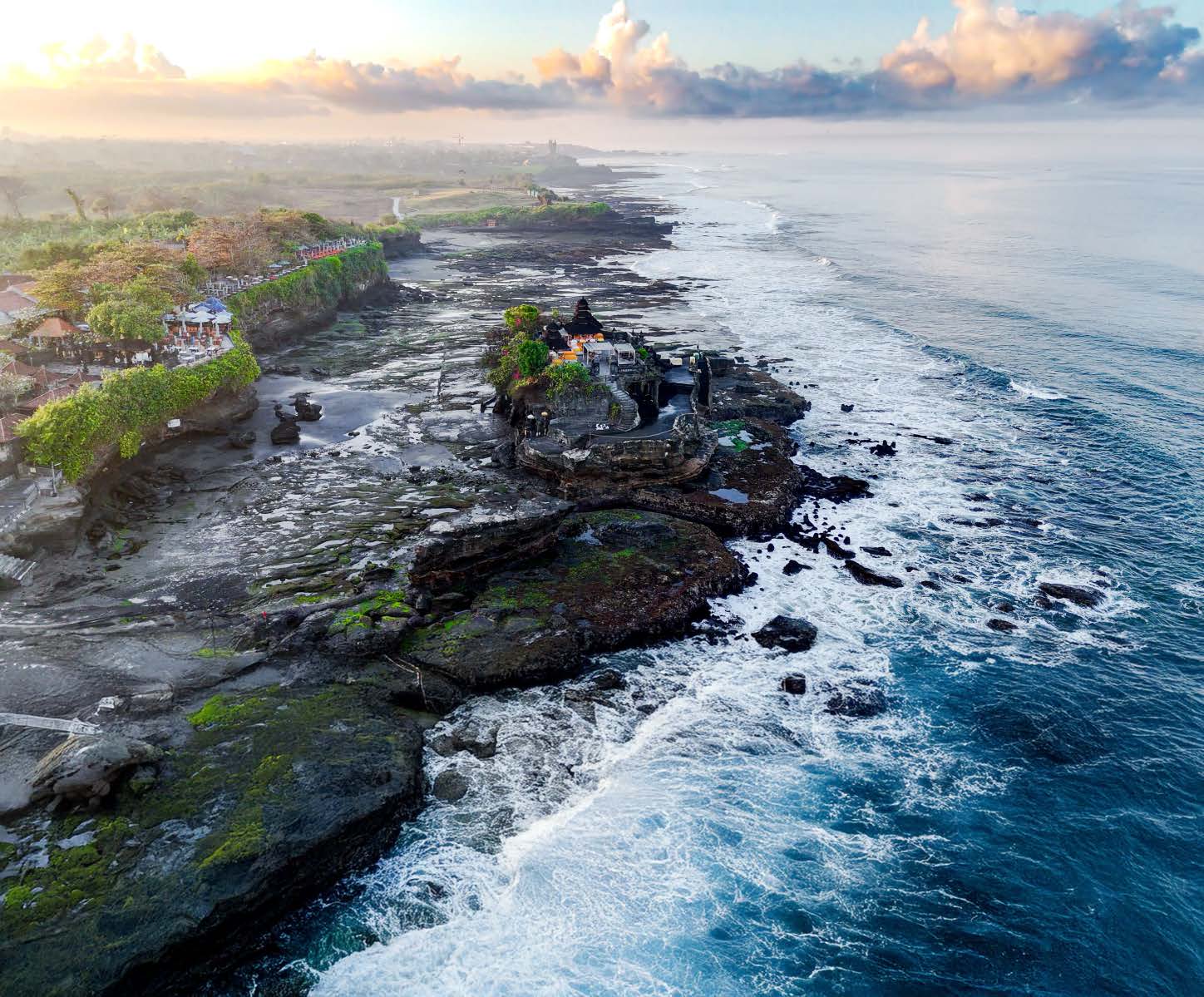 Tanah Lot sea temple on its rock at sunrise, seen from the air