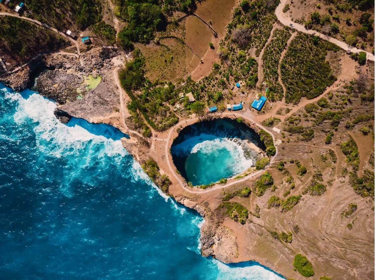 The cliffs and turquoise water of Nusa Penida from the air